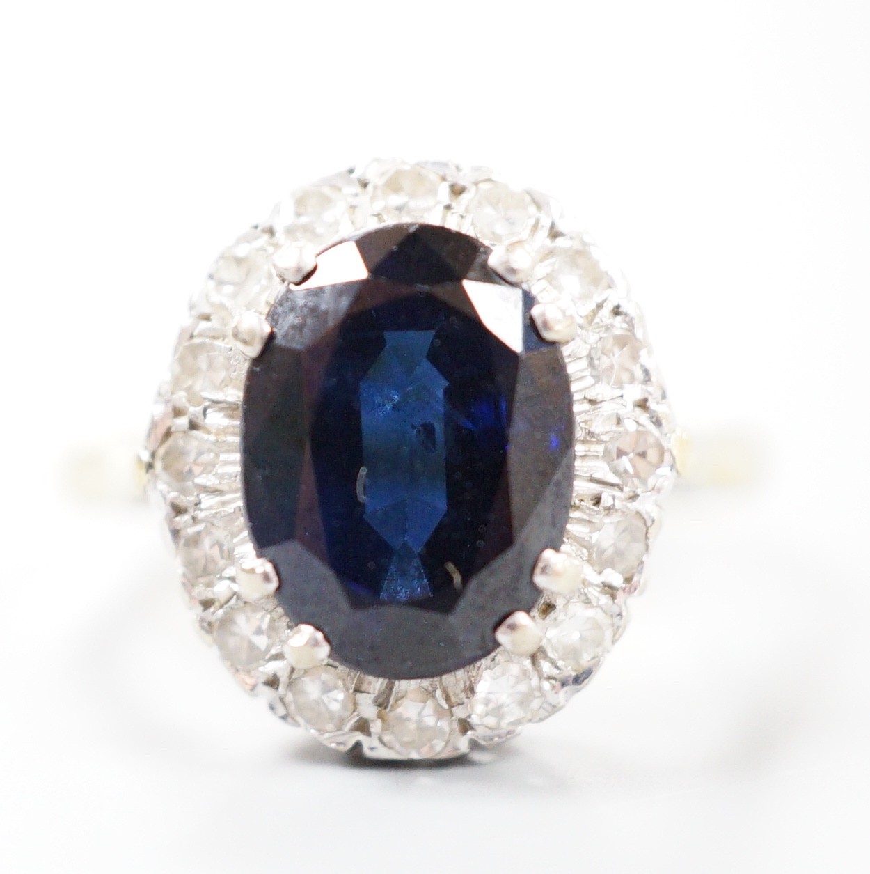 A modern 18ct gold, sapphire and diamond set oval cluster ring, size M, gross weight 4.9 grams.